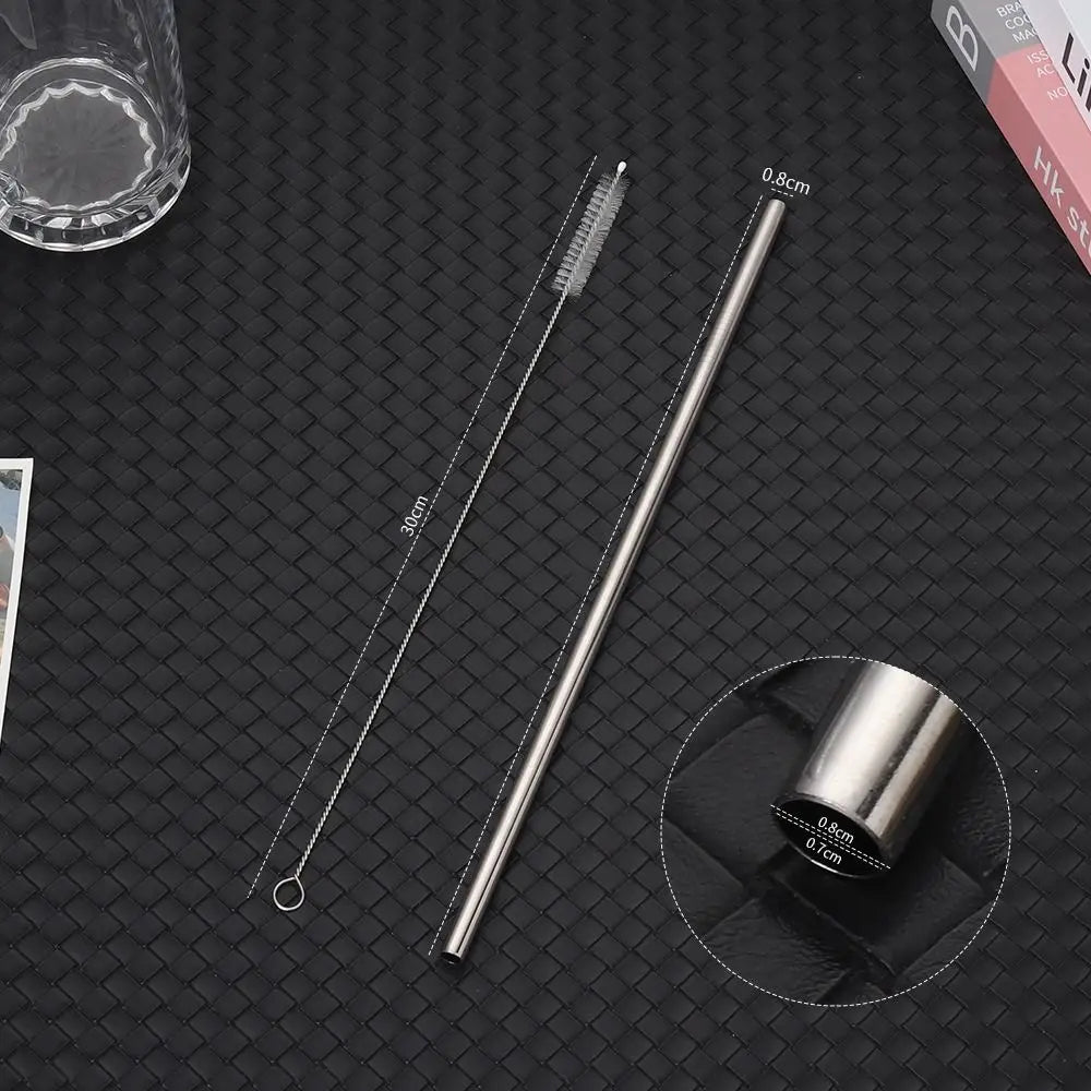 A set of long, thin stainless steel straws with measuring marks displayed on a dark surface.