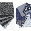 A bundle of cotton fabric squares featuring various floral, dot, and striped patterns in black, white, and blue.