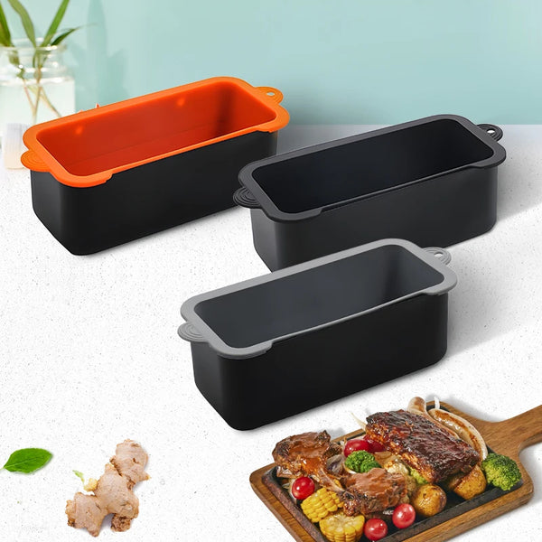 Three black silicone grease cup liners with orange lids and a wooden serving board containing meat and vegetables