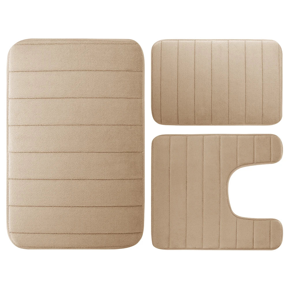 A set of three beige plush memory foam bath mats with ribbed non-slip backing.