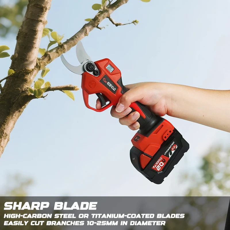 A hand holds an orange cordless electric pruning shear with a sharp blade against a tree branch.