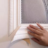 A hand is peeling a white foam wall panel from a gray textured backing for installation.