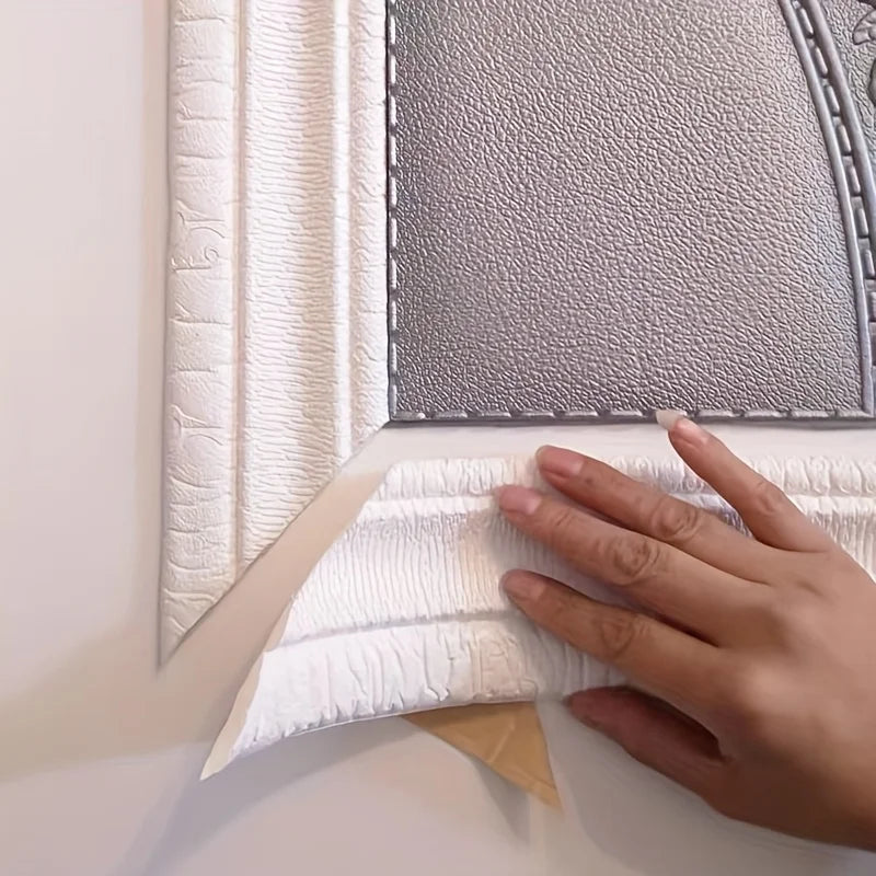A hand is peeling a white foam wall panel from a gray textured backing for installation.