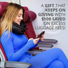 A smiling woman in a blue jumpsuit is using a smartphone while seated in a red car seat.