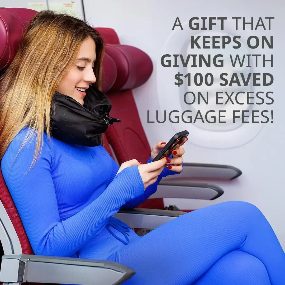 A smiling woman in a blue jumpsuit is using a smartphone while seated in a red car seat.