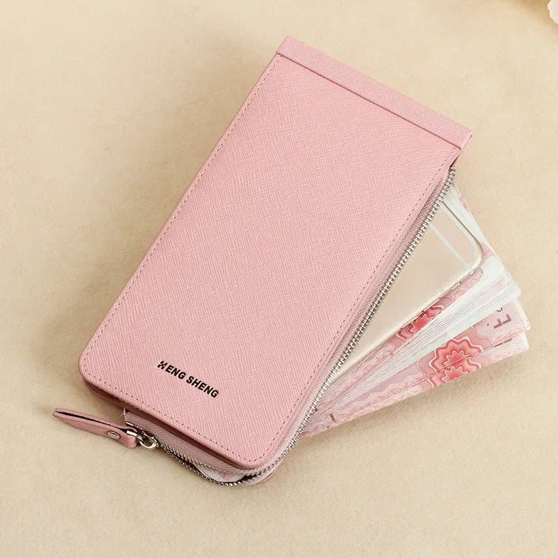 Pinkes, schlankes Kunstleder-Multikarten-Wallet mit silbernem Reißverschluss auf hellem Beige