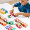 A young child is building with colorful wooden blocks and letter tiles on a white table.