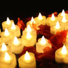 A close-up of heart-shaped flameless LED candles glowing warmly amidst red fabric.