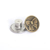 A brass button and a silver button are shown next to a metal button holder.