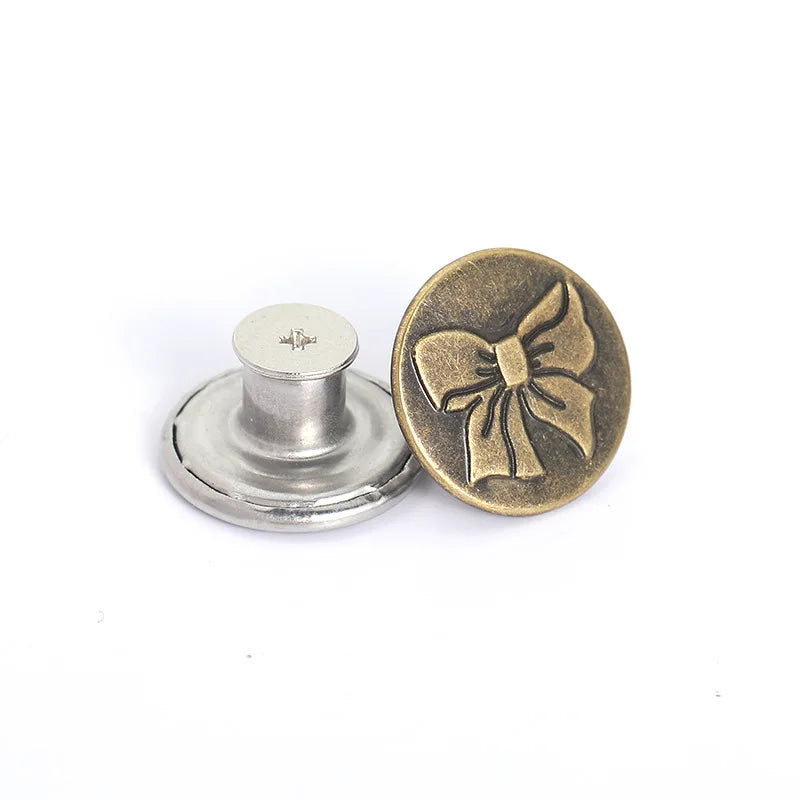 A brass button and a silver button are shown next to a metal button holder.