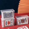 Clear plastic storage boxes containing playing cards and business cards resting on a red surface.