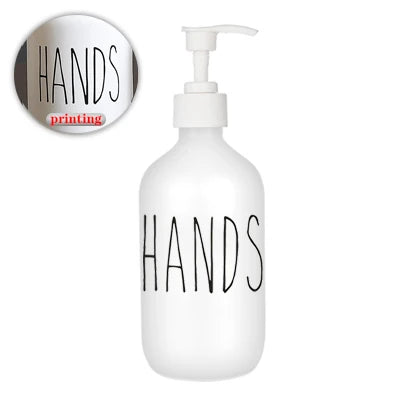 White refillable soap dispenser bottle with the word HANDS printed on it.