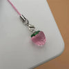 A pink resin strawberry charm attached to a silver keychain with a pink cord.