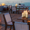 Outdoor decoration featuring pillar candles on a wooden deck with seating and a table.