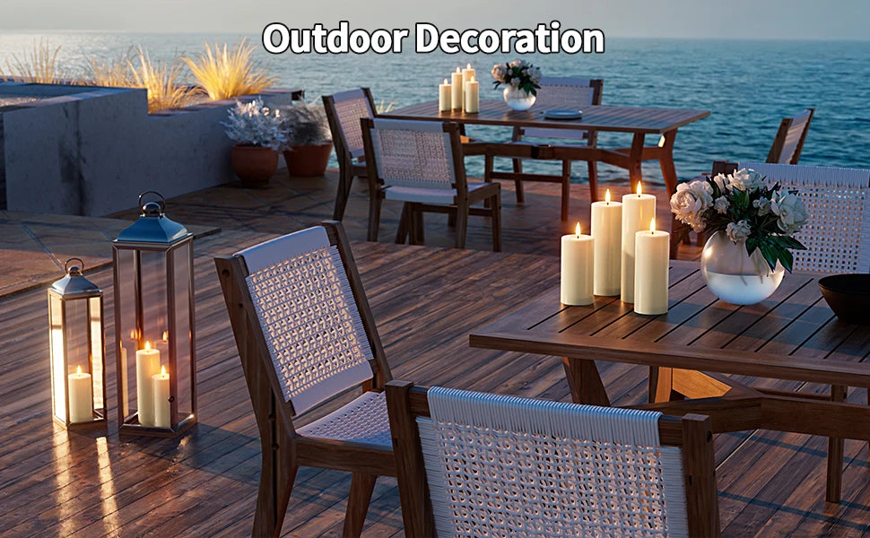 Outdoor decoration featuring pillar candles on a wooden deck with seating and a table.