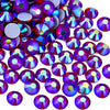A close-up view of various iridescent purple and blue rhinestones scattered on a white background.