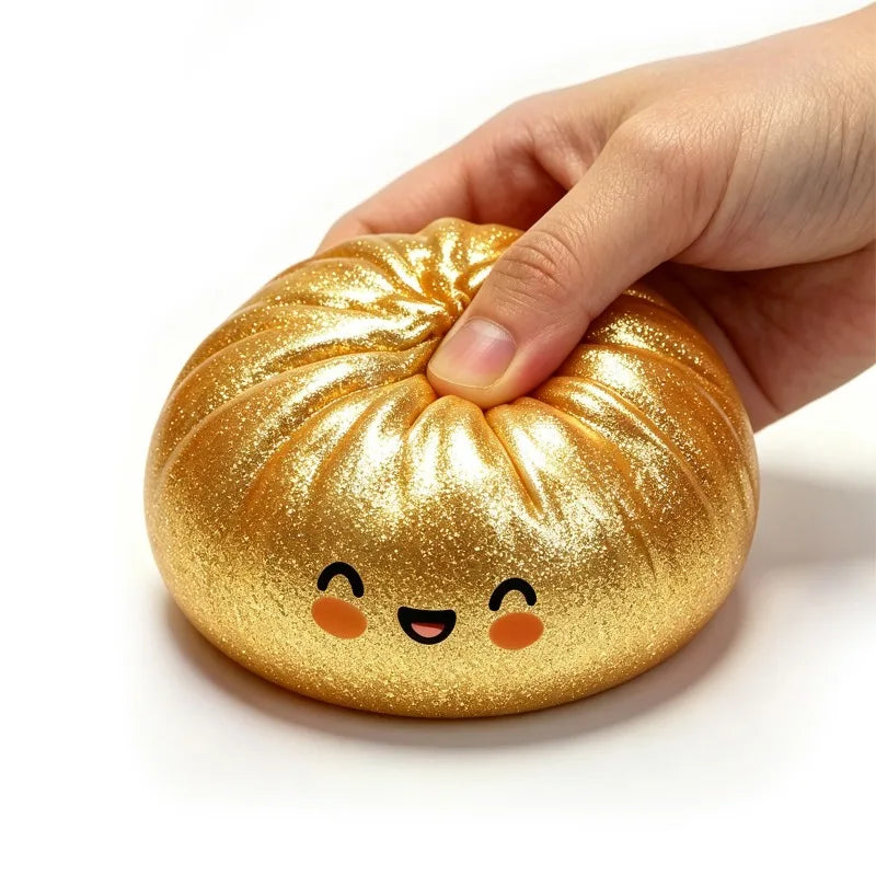 A hand is squeezing a golden, squishy dumpling-shaped fidget toy with cute facial features.
