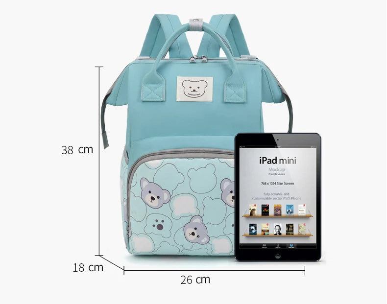 A light blue bear print waterproof diaper backpack next to an iPad mini tablet.