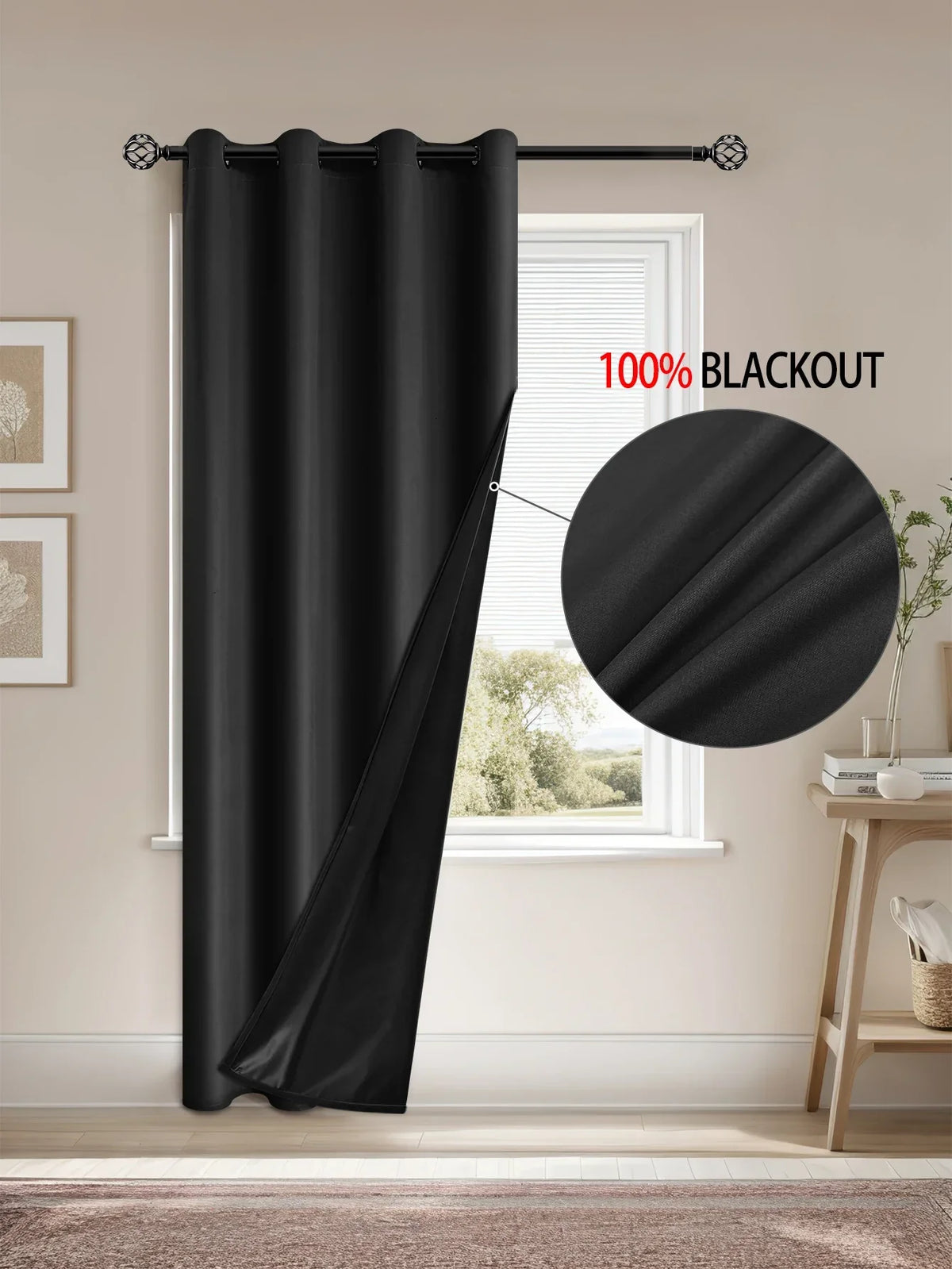 A black blackout curtain is installed on a window, showing its drape and mounting hardware.
