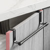 A black metal punch-free over-cabinet towel rack mounted on a light gray cabinet door.