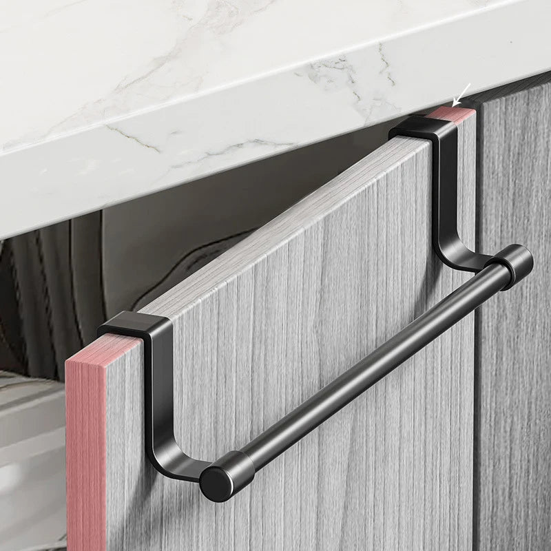 A black metal punch-free over-cabinet towel rack mounted on a light gray cabinet door.