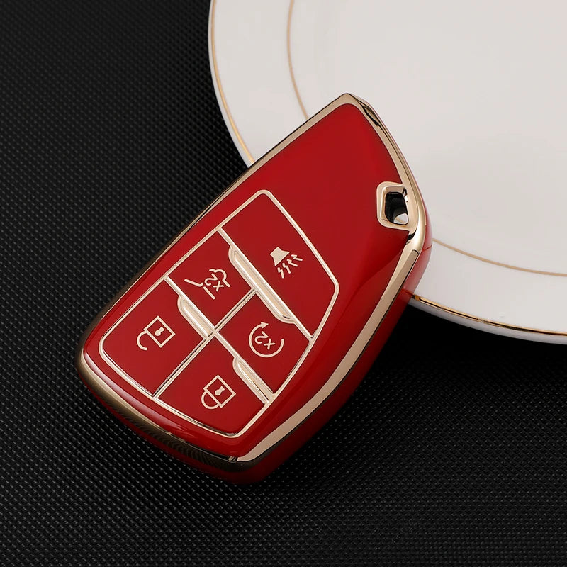 A red durable TPU car key fob cover with a gold trim rests on a white plate.
