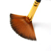 A close-up view of a gold-handled flat brush with a brown nylon bristle tip.