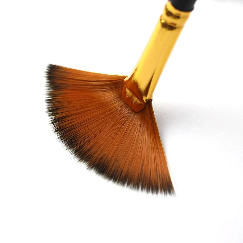 A close-up view of a gold-handled flat brush with a brown nylon bristle tip.