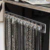 Wall-mounted acrylic jewelry organizer featuring crystal knobs and silver chains.