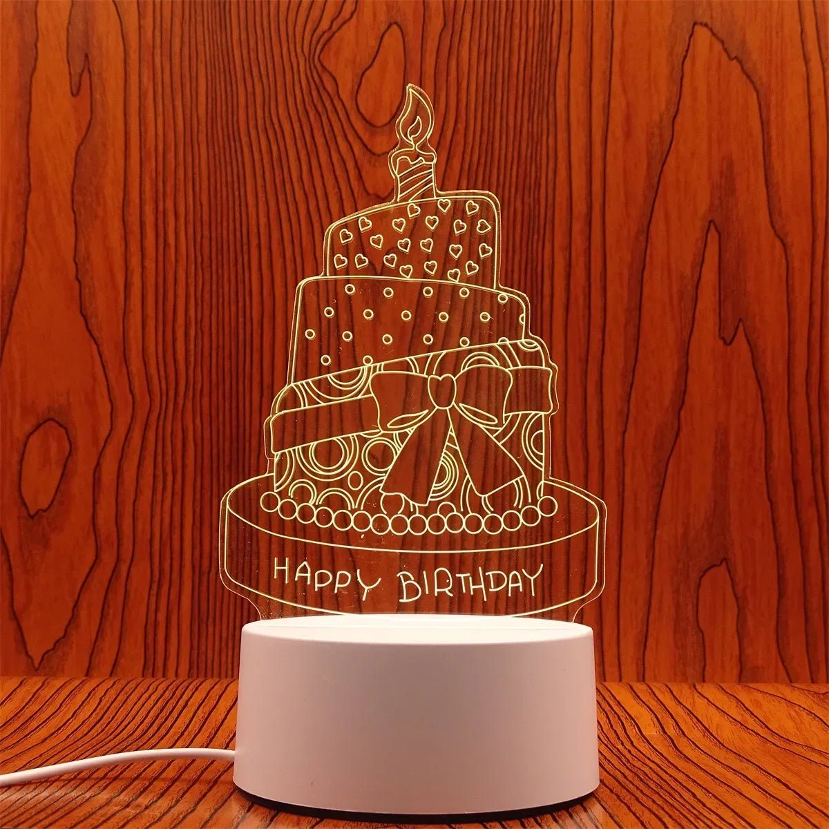 A laser-cut silhouette of a birthday cake with candles and the words HAPPY BIRTHDAY on a light wood background.