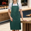 A woman wearing a dark green apron with pockets standing in a kitchen setting.