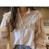 A white vintage lace long sleeve blouse with ruffled details is displayed in a mirror.