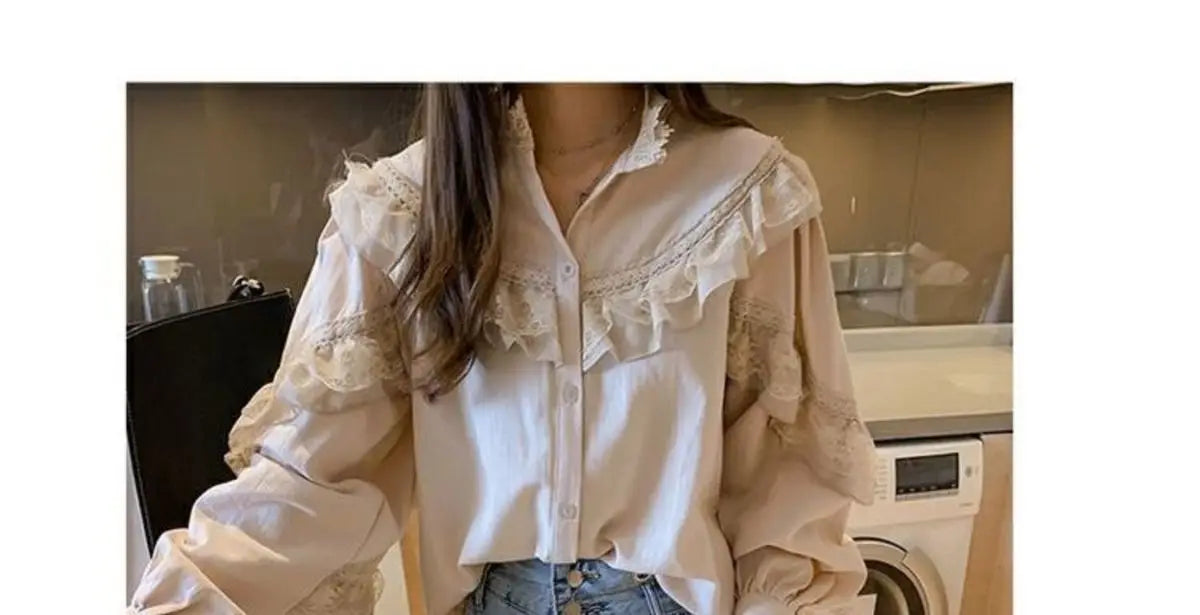 A white vintage lace long sleeve blouse with ruffled details is displayed in a mirror.