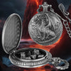 A silver dragon-themed pocket watch case is open, revealing a set of seven metal polyhedral dice against a fiery background.