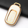 A white and gold anti-scratch TPU protective case for a Honda key fob, shown against a black fabric background.