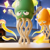 A green octopus toy with large eyes and tentacles is shown on a wooden surface.