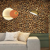 A modern interior featuring a sofa and a lamp against a leopard print wallpaper.