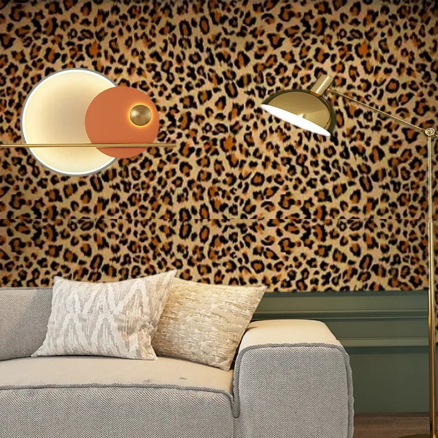 A modern interior featuring a sofa and a lamp against a leopard print wallpaper.