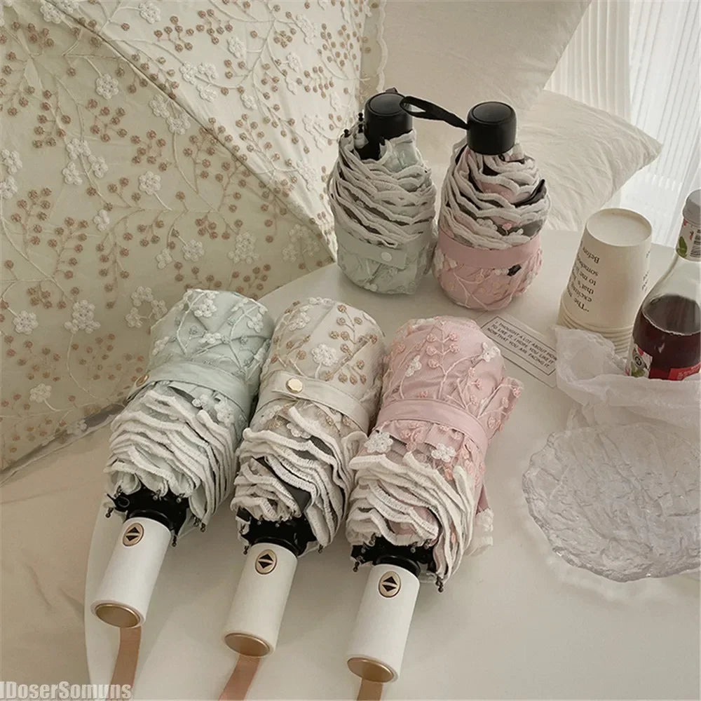 A white and pink lace double-layer folding umbrella is shown with its components and packaging.
