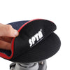 A hand holds a black polishing pad with red trim, used for car care.