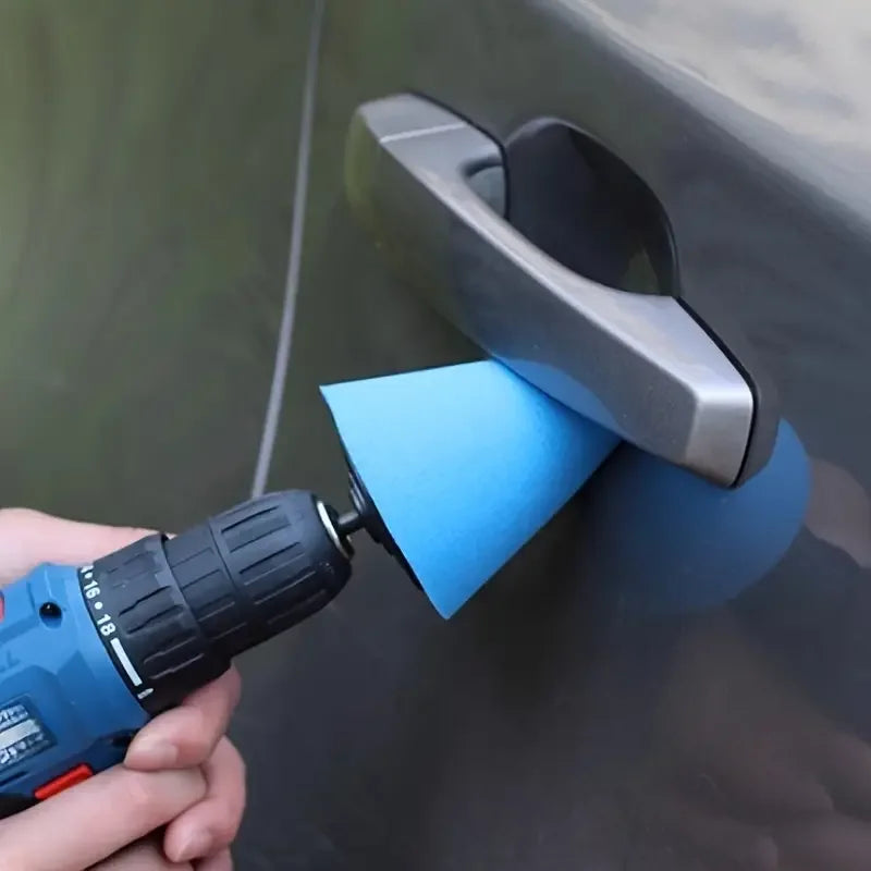 A hand holds a blue drill polishing sponge cone kit against a gray automotive surface.