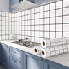 A kitchen splashback featuring white square tiles and blue cabinetry with rolled self-adhesive stickers.