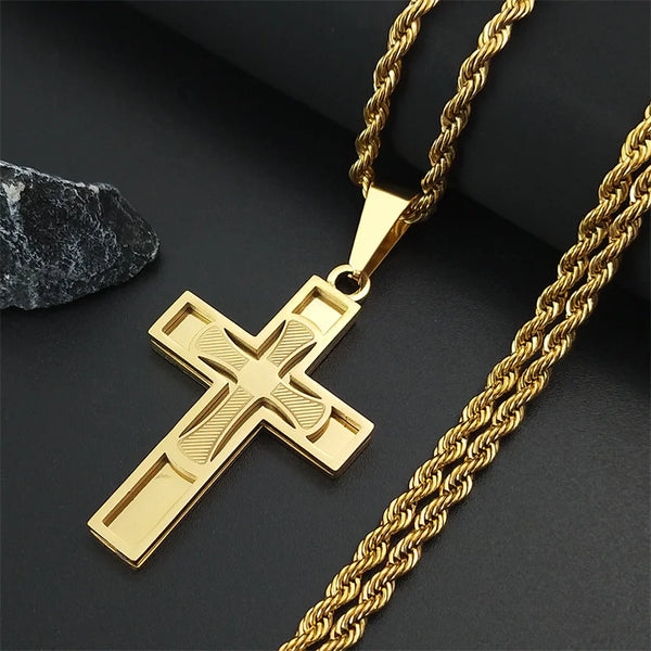 Collier en croix en acier inoxydable or avec pendentif barre et chaîne dorée sur fond sombre.