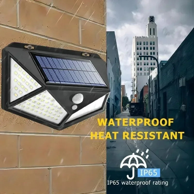 Schwarzer wetterfester Scheinwerfer mit Solarpaneel und LED-Licht an einer beigen Ziegelwand.