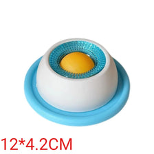 A white ceramic pet grooming tool with a blue insert and a yellow ball inside.