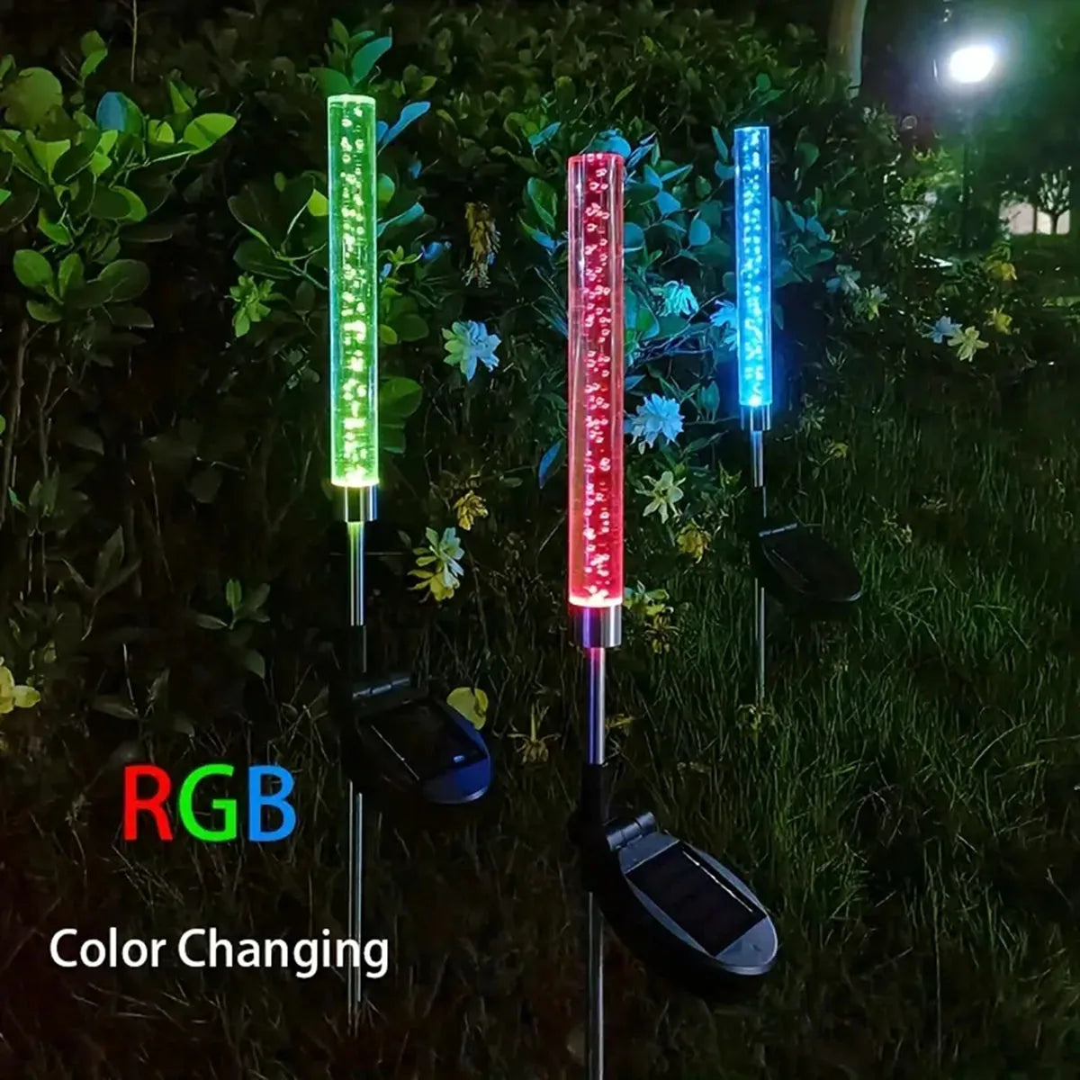 Three vertical LED lights with RGB color changing capabilities illuminating a garden path.