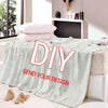 A light gray flannel throw blanket with a DIY design print displayed on a bed.