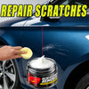 A hand applies a yellow wax to repair scratches on a blue car surface.