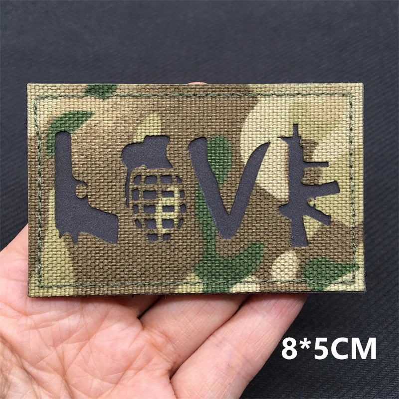 A rectangular camouflage patch featuring the letters LOVE and a globe design on a fabric background.