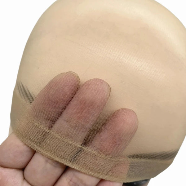 A hand is holding a beige HD Invisible Wig Cap, showing the sheer fabric and elastic band.